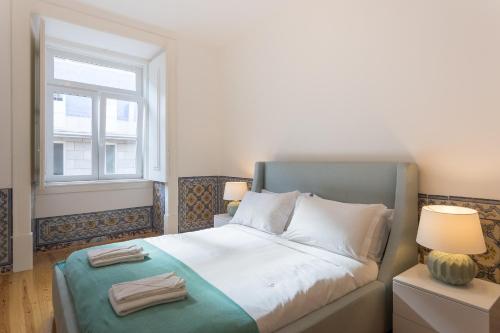 una camera da letto con un grande letto e una finestra di Chiado Apartment - Holiday Rental in Lisbon a Lisbona