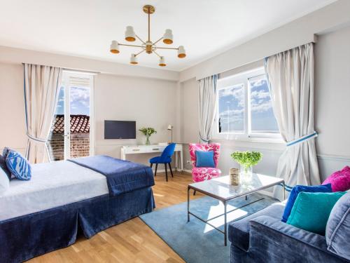 a bedroom with a bed and a couch and a table at La Malandrina - Apartments & Suites in Taormina