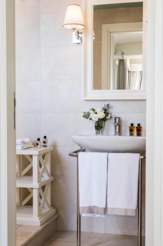 a bathroom with a sink and a mirror and towels at La Malandrina - Apartments & Suites in Taormina