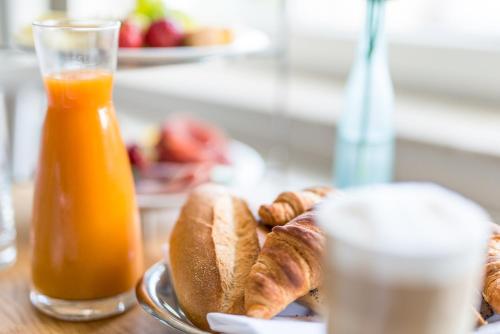 a plate of bread and a glass of orange juice at Strandhaus Ahrenshoop in Ahrenshoop