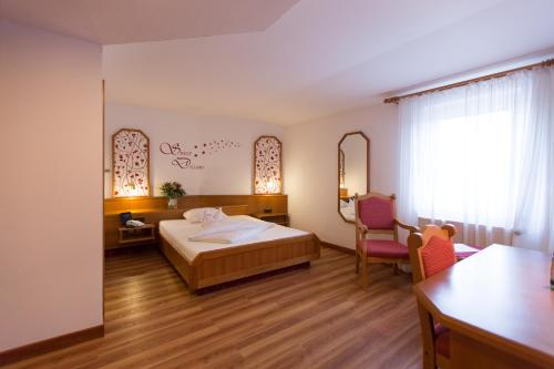 a bedroom with a bed and a table and chairs at Fränkischer Hof in Rehau
