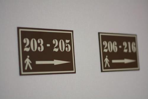 two signs hanging on a wall with arrows at UYUTNYY DOM in Taraz