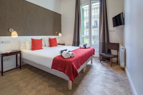 a hotel room with a large bed with a red blanket at Habitat Apartments Garden View in Barcelona