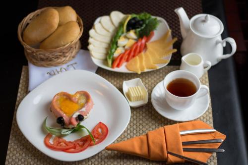 a table with two plates of food and a cup of tea at UYUTNYY DOM in Taraz