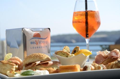 een bord eten met een drankje en een broodje bij Hotel Belvedere in Torre dell'Orso