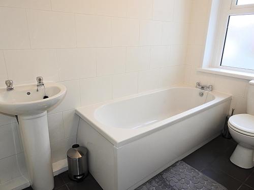 a white bathroom with a sink and a tub and a toilet at Parks Nest 1 in Hull