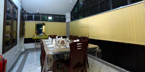 a dining room with a table and chairs and yellow walls at Novem Inn- Sylhet in Sylhet