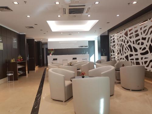 a waiting room with white chairs and a wall at LCB Hotel Fuenlabrada in Fuenlabrada