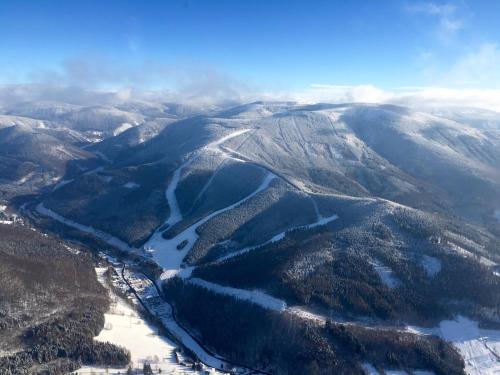 an aerial view of a mountain valley with a river at Apartmany Kouty in Loučná nad Desnou
