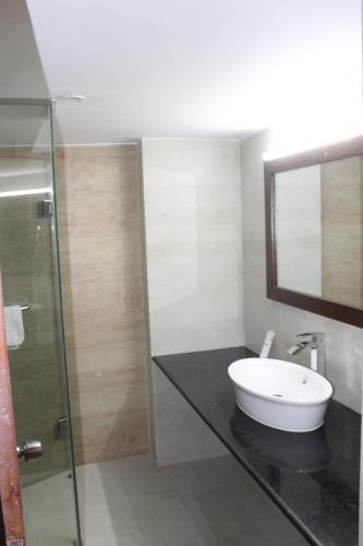 a bathroom with a sink and a glass shower at La Vista Hotel in Sylhet