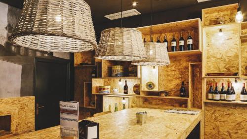 bar z 2 żyrandolami i blatem z butelkami wina w obiekcie Hotel Piñupe w mieście Lekeitio