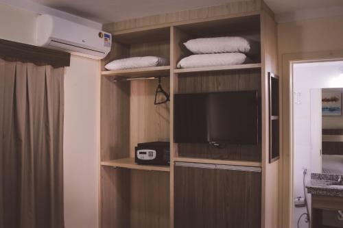 Habitación con TV y estanterías con toallas en Via Lacqua Hospedagem e Reservas, en Caldas Novas