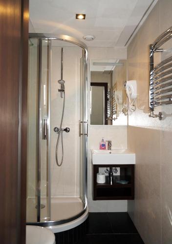 a bathroom with a shower and a sink at Aparthotel Łódź 55 Piotrkowska in Łódź