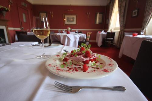 a plate of food on a table with a glass of wine at Worsley Arms Hotel in Hovingham