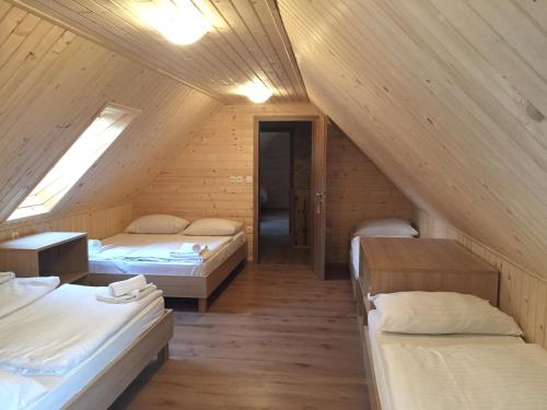 a attic room with three beds and a window at Apartmaji in sobe Tina in Kranjska Gora
