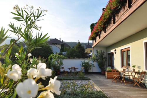 a garden with tables and chairs on a house at Gästehaus Hofer in Gumpoldskirchen