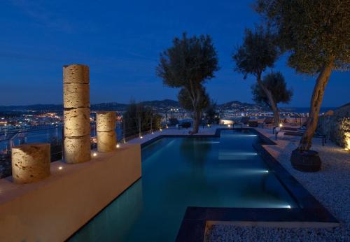 a swimming pool at night with trees and lights at Hotel La Torre del Canonigo - Small Luxury Hotels in Ibiza Town