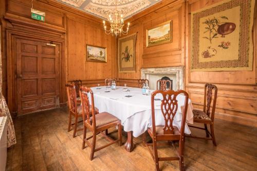 a dining room with a table and chairs and a chandelier at Castle Bromwich Hall; Sure Hotel Collection by Best Western in Birmingham