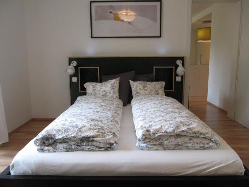 a bed with two pillows on it in a room at gartenhouse in St. Wolfgang