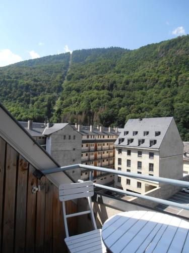un balcon avec une table et une vue sur une ville dans l'établissement Appartement T2, à Luchon