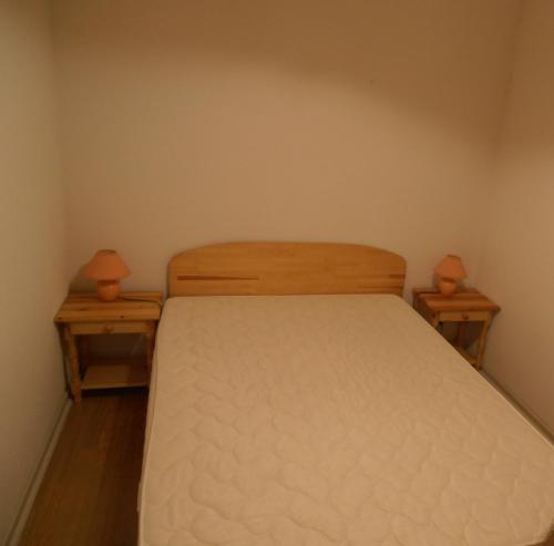 niewielka sypialnia z łóżkiem z 2 szafkami nocnymi w obiekcie Appartement T2 w mieście Luchon