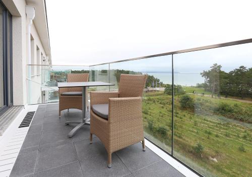 a patio with a table and chairs on a balcony at DORMERO Strandapartments Rügen in Binz