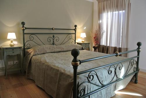 a bedroom with a bed and two tables and a window at Agriturismo Colombera in Quarto dʼAltino
