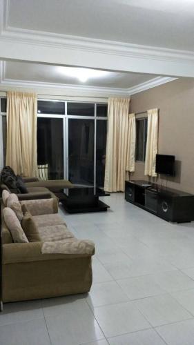a living room with a couch and a tv at Rose Apartment Kea Farm in Cameron Highlands