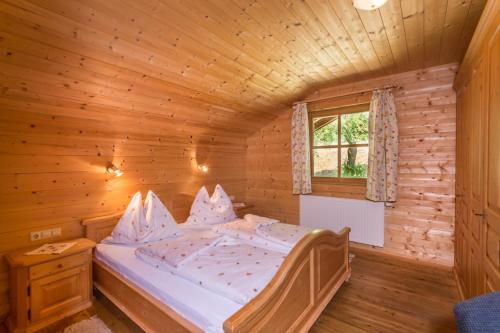 ein Schlafzimmer mit einem Bett in einer Holzhütte in der Unterkunft Hacklgut in Radstadt