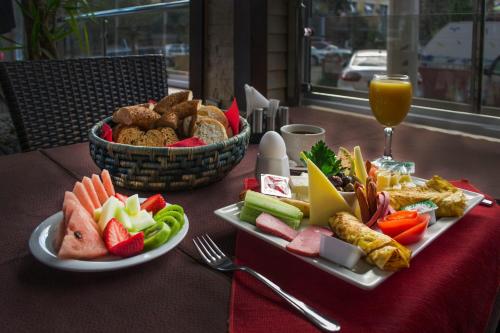 una mesa con dos platos de comida y un vaso de jugo de naranja en My Home Apart, en Alanya