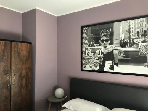 una camera da letto con la foto di una donna con gli occhiali da sole di Via Roma suite a Ortona