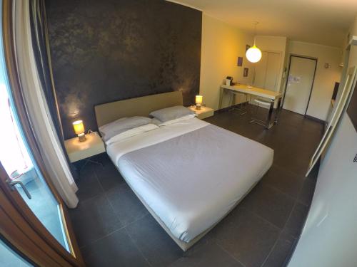 コゼンツァにあるSuite Roomsの大きな白いベッドと2つのランプがある寝室