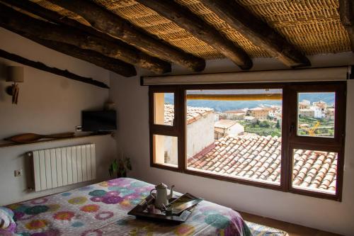 1 dormitorio con cama y ventana grande en Rails del Temple, en Castellote