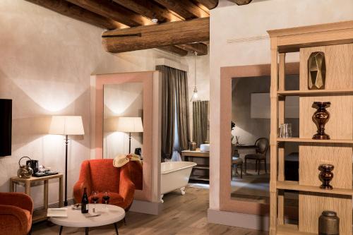 a living room with a bath tub and a bedroom at La Barchessa di Villa Pisani in Lonigo