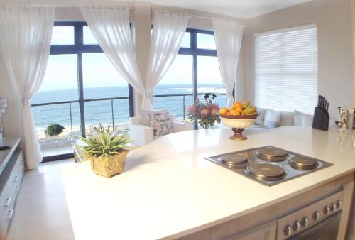 a kitchen with a counter with a view of the ocean at Point Village Accommodation - Santos 61/62 in Mossel Bay