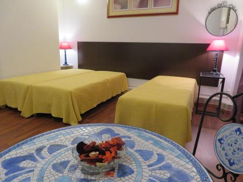 Pokój z dwoma łóżkami i stołem z miską jedzenia w obiekcie A Ponte Marques de Pombal w Lizbonie