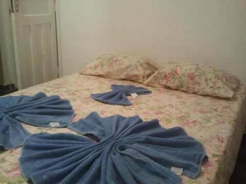 a bed with blue sheets and pillows on it at Pousada Preludio in Conservatória