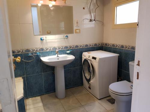 La salle de bains est pourvue d'un lave-linge et d'un lavabo. dans l'établissement Choueifat Residence Families Only, au Caire