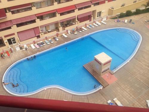 une vue aérienne d'une grande piscine dans un hôtel dans l'établissement Residencial Jardines Del Mar, à Puerto de Santiago