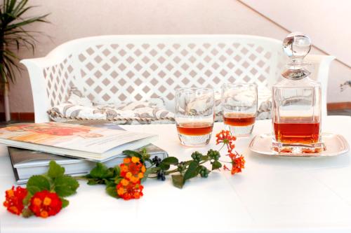 a table with two glasses and books and flowers at Agriturismo Bocci in Castiglione della Pescaia