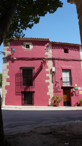 un bâtiment rouge avec deux fenêtres sur une rue dans l'établissement Hotel La Casa del Canónigo, à Caracenilla