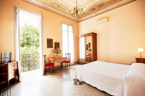 a bedroom with a bed and a large window at Résidence La Villa Léonie in Nice