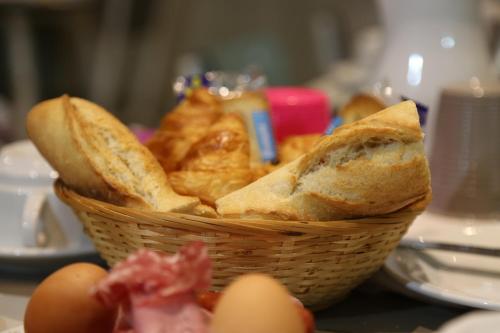 a basket of bread sitting on a table with eggs at Hotel Des Arenes in Paris