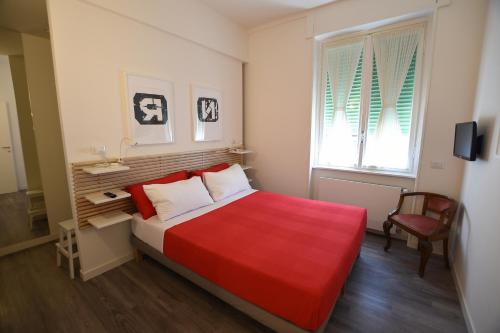 a small bedroom with a red bed and a chair at Le Rondinelle in Como