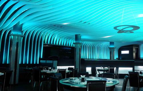 a dining room with a blue ceiling and tables and chairs at Malligi,Hampi in Hospet