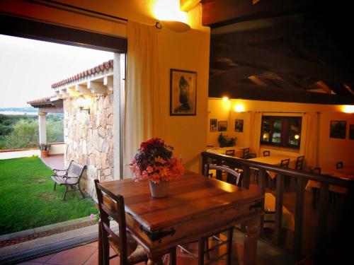 a dining room with a table and a large window at Agriturismo Sa Mendhula in Cugnana