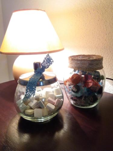two glass jars filled with rocks and a lamp on a table at Agriturismo Sa Mendhula in Cugnana