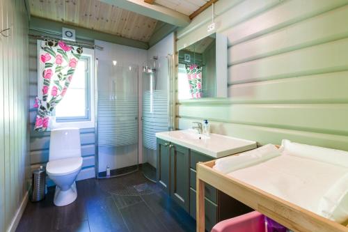 uma casa de banho verde com um WC e um lavatório em Gladheim em Stranda