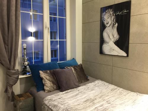 グダニスクにあるOld Town Apartment / Igielnickaのベッドルーム1室(ベッド1台付)が備わります。壁に絵が飾られています。