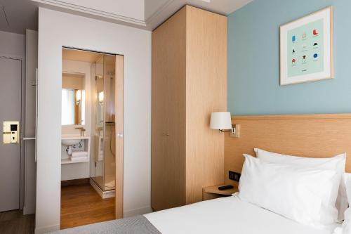 a hotel room with a bed and a bathroom at Hôtel Magellan in Paris